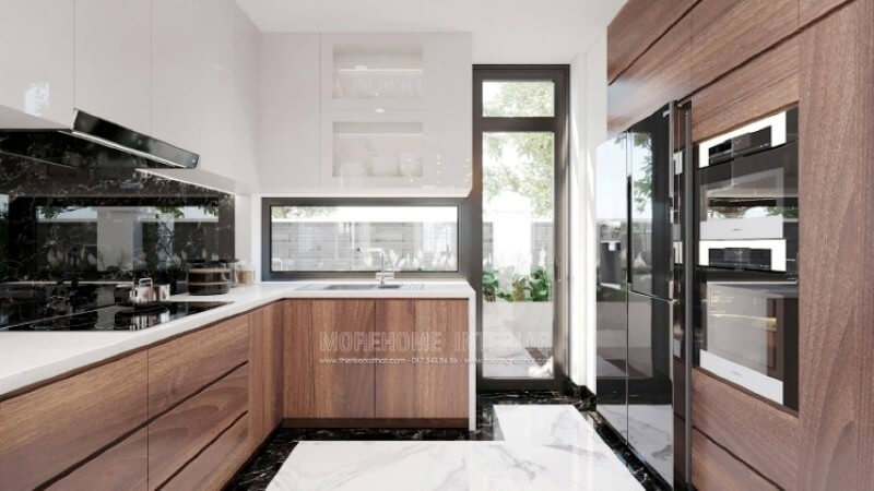 Là một trong những xu hướng thiết kế nội thất ấn tượng trong những năm tới, bố trí phòng bếp hiện đại tôn lên vẻ đẹp mộc mạc nhưng không kém phần sang trọng của gỗ điển hình là gỗ óc chó veneer . Loại gỗ rất được ưa chuộng trong các siêu xe bởi vẻ đẹp ấn tượng từ vân, màu gỗ. Như trong ý tưởng trang trí phòng bếp tại biệt thự Vinhomes Imperia, sự hài hòa tôn lên nét đẹp giữa truyền thống và hiện đại, tủ bếp dưới gỗ óc chó và tủ bếp trên gỗ công nghiệp trắng bóng. Tủ bếp gỗ công nghiệp
